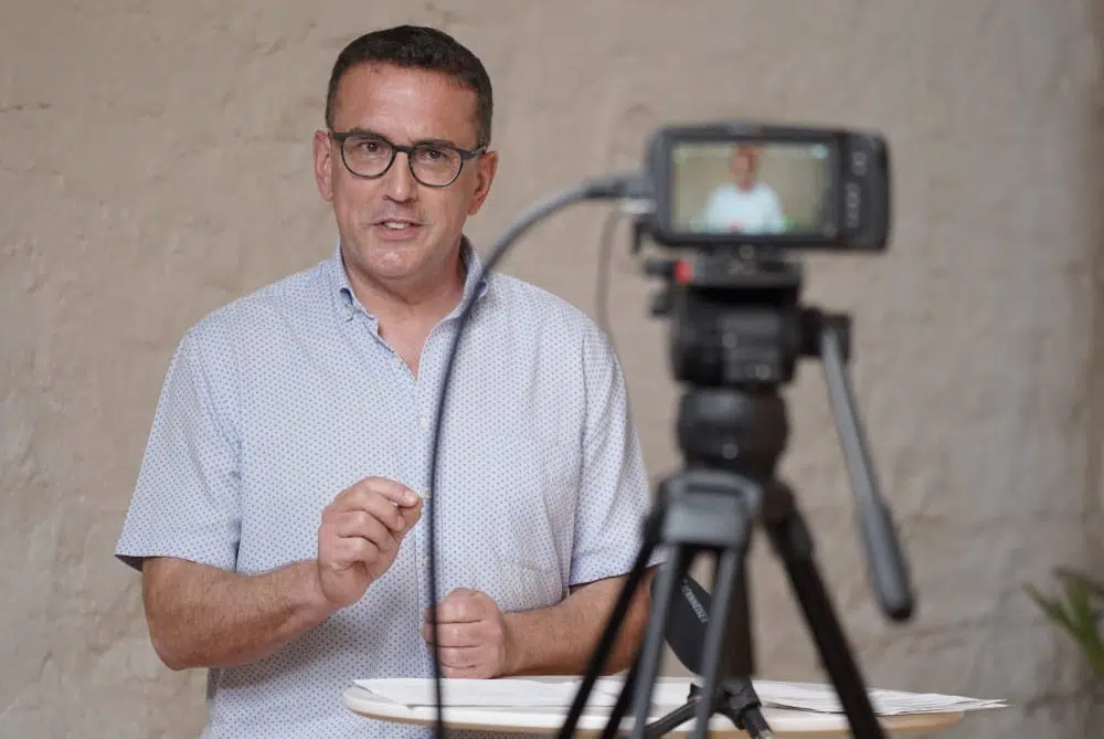 Homme avec des lunettes parle devant une caméra