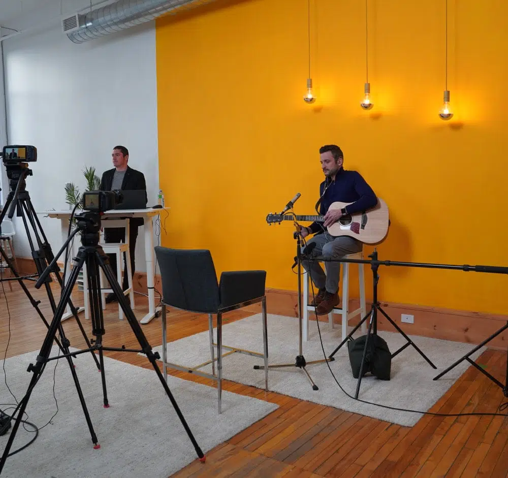 Homme qui joue de la guitare dans un set-up de studio de production audiovisuelle