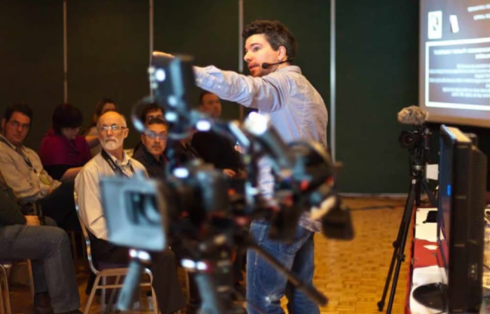 Formateur en train de donner une formation à une audience, filmé par des caméras